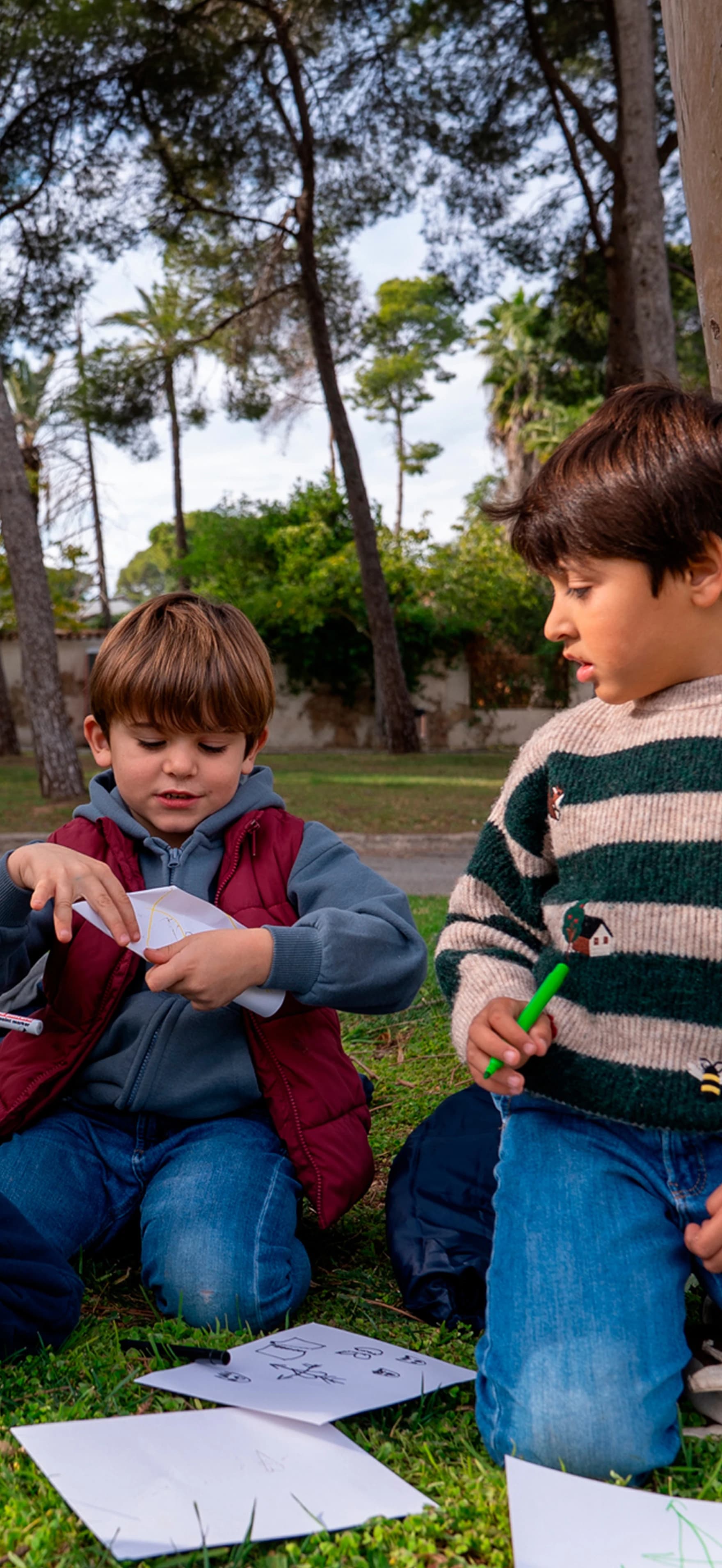Imagen de dos niños jugando en el suelo con unos cochecitos de juguete.