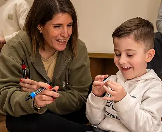 Terapeuta y niño sonriendo durante una sesión grupal de JUMP.